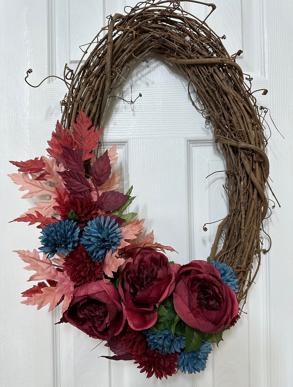 Oval grapevine wreath in burgundy and London blue cornflowers