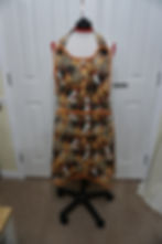 Front view of the full coverage apron showing the large front pocket, the large black buttons holding the neck strap.