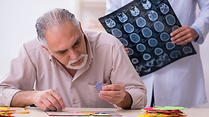 Medico mostra referti a un uomo intento a comporre un puzzle, rappresentazione delle diverse forme di demenza.