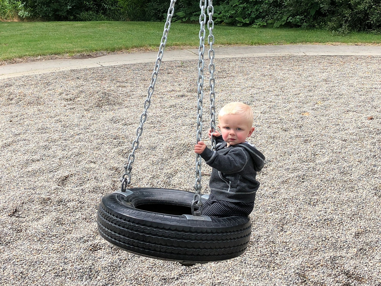 Little boy swinging on a tire swing at Yakima Sportsman State Park.