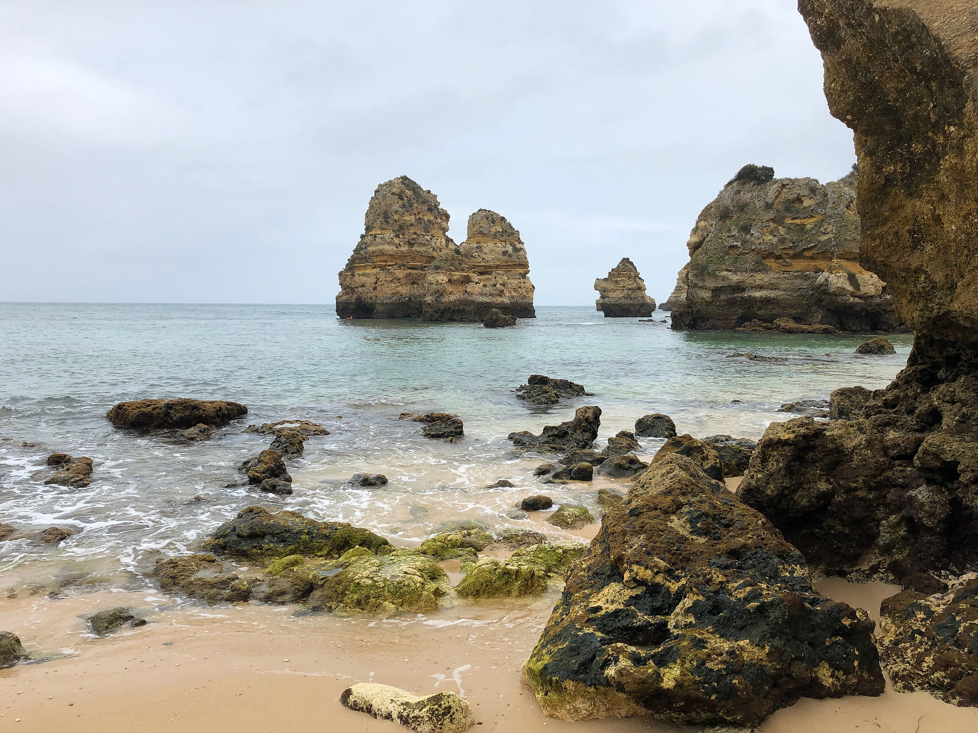 Golden sands and rock formations at Praia do Camilo.