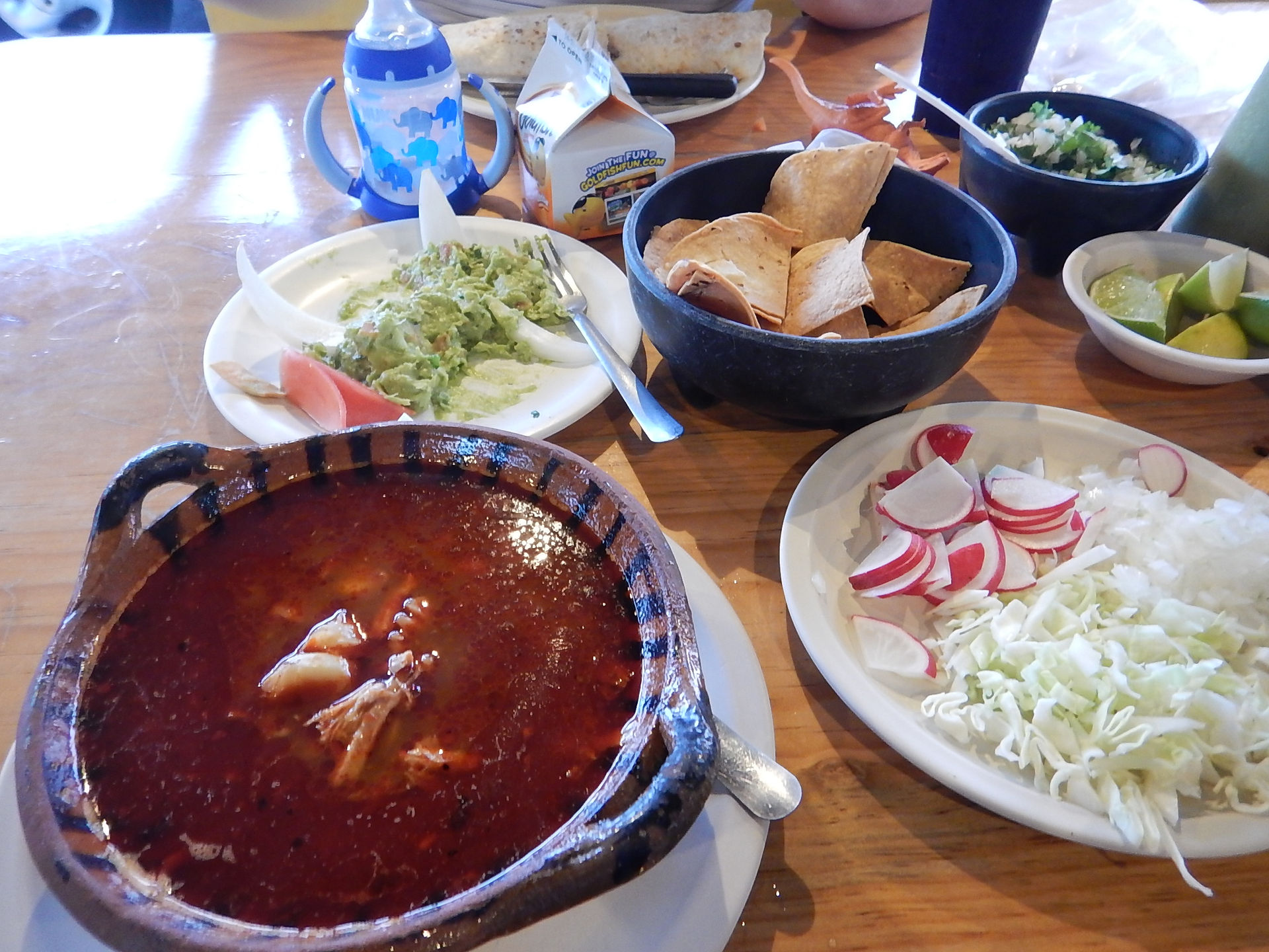 Table full of Mexican food including tortilla soup, chips and guacamole at Los Otates