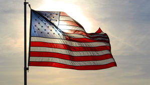 American flag flaps in the wind at sunset