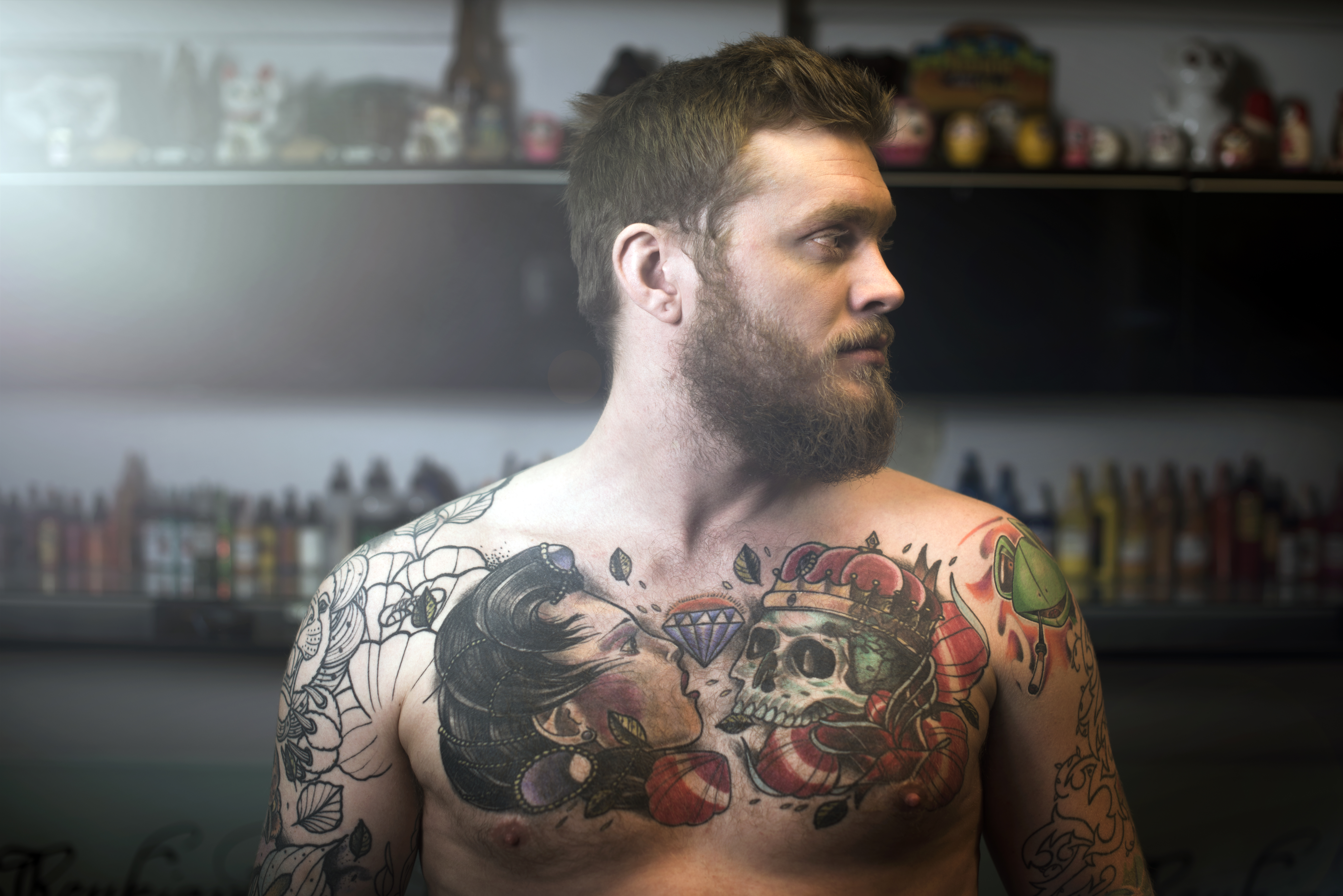 Mann mit Brusttattoo: Totenkopf, Frau, Diamant