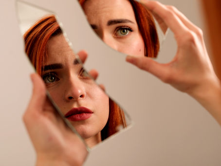 a woman looking in a broken mirror with distress