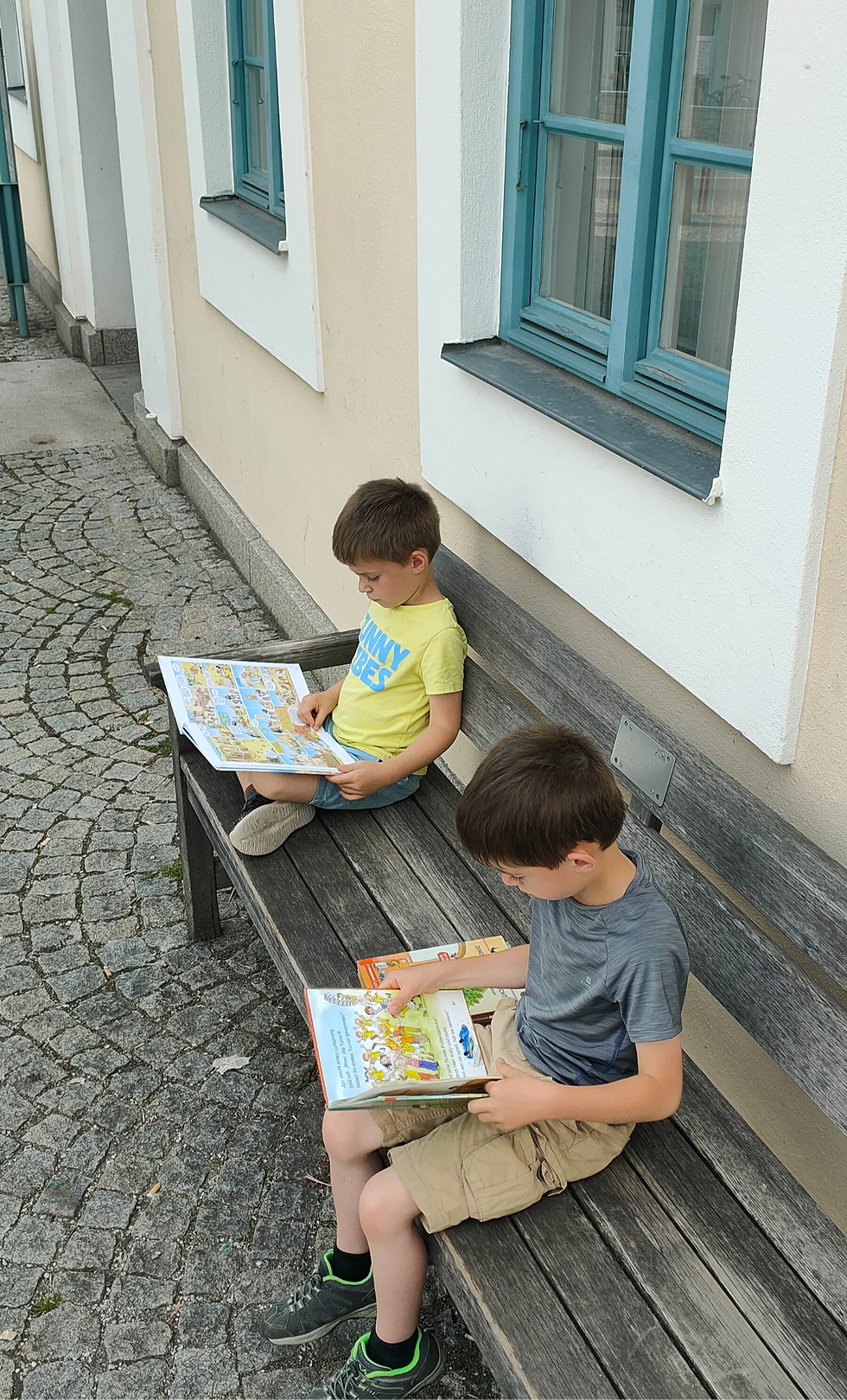 Kinder Lesen einen Buch auf einem Bank