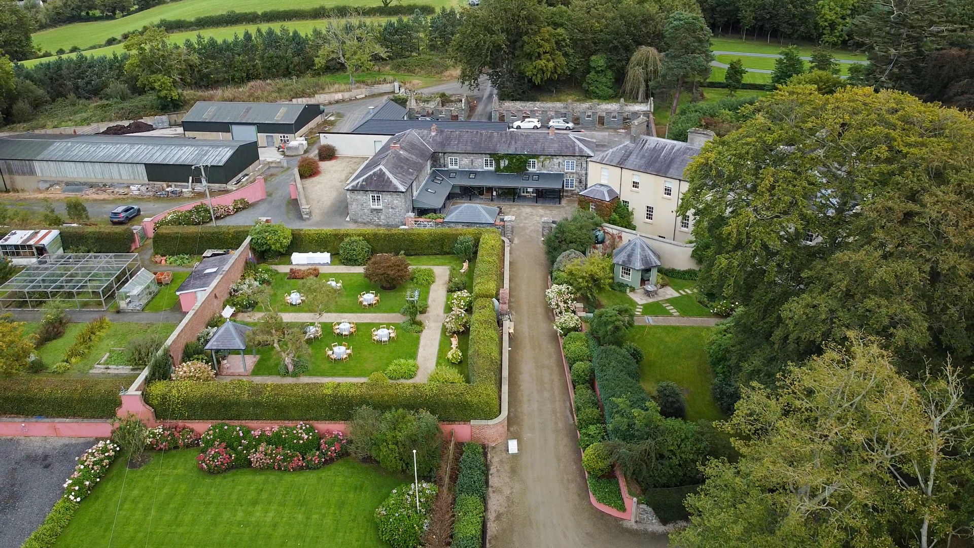 An aerial shot a Georgian style house surrounded by lush gardens, trees and fields. Taken at Northern Ireland wedding venue Tullyveery House by Northern Ireland Photographer and Videographer Steenson Film and Photography.