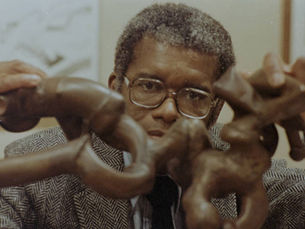 Artist Richard Hunt poses with his copper sculpture, "Coil."