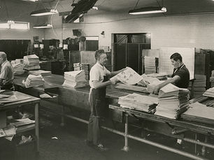 Employees of Springfield Newspapers, Inc. fold and sort new newspaper issues.