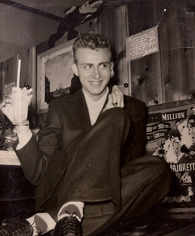 An unidentified man holds a milkshake and a lollipop.