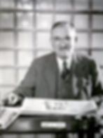 H. S. Jewell, owner of the Springfield Leader, the Springfield Press, and later the president of Springfield Newspapers, Inc., seated at a desk. Jewell wears a suit and glasses and is smoking a cigar.