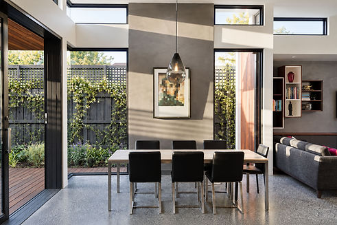 Naturally lit dining room with high-level glazing and garden connections at Ivan Street, designed by Adapt Architecture.