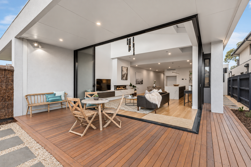 Covered timber deck connecting seamlessly with the open-plan living spaces through large sliding glass doors.