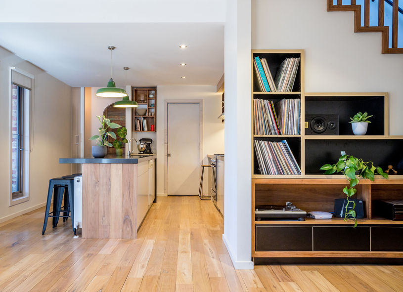 Timber kitchen island and custom living room joinery within the renovated open plan interior.