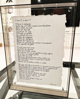 Caligrafia personalizada feita à mão com tinta preta em papel rústico cortado manualmente, emoldurada pela cliente como obra de arte única.