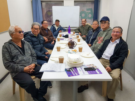 Group of 8 Vietnamese men sitting at a table and smiling