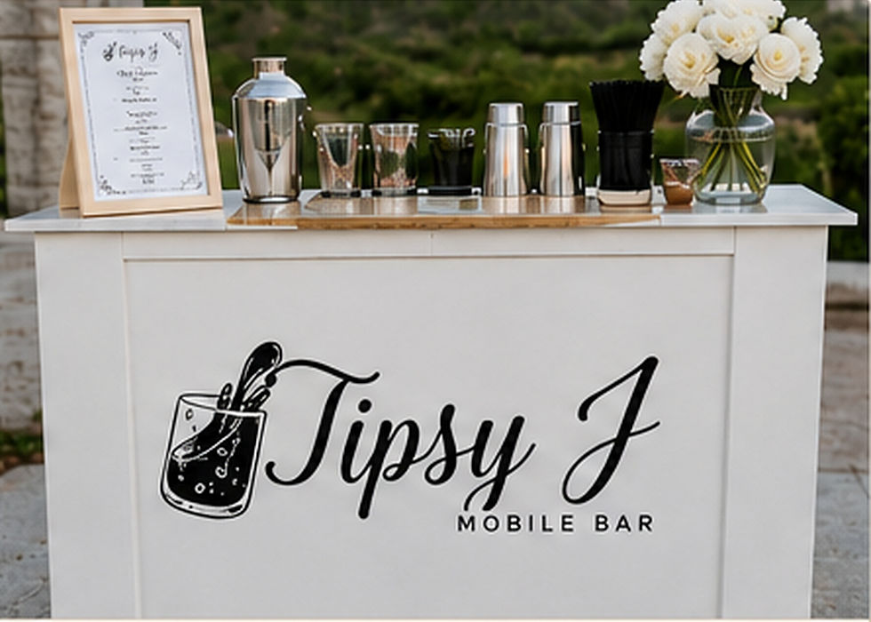 White Tipsy J Mobile Bar counter with logo, bar tools, and flowers outdoors