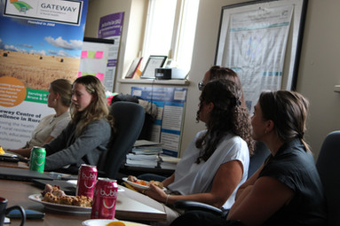 Members of the OBI Team listening to Madi, Research Assistant at Gateway CERH present her programs