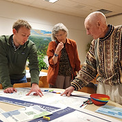 three people gather, looking at a map of Mystic River Connecticut