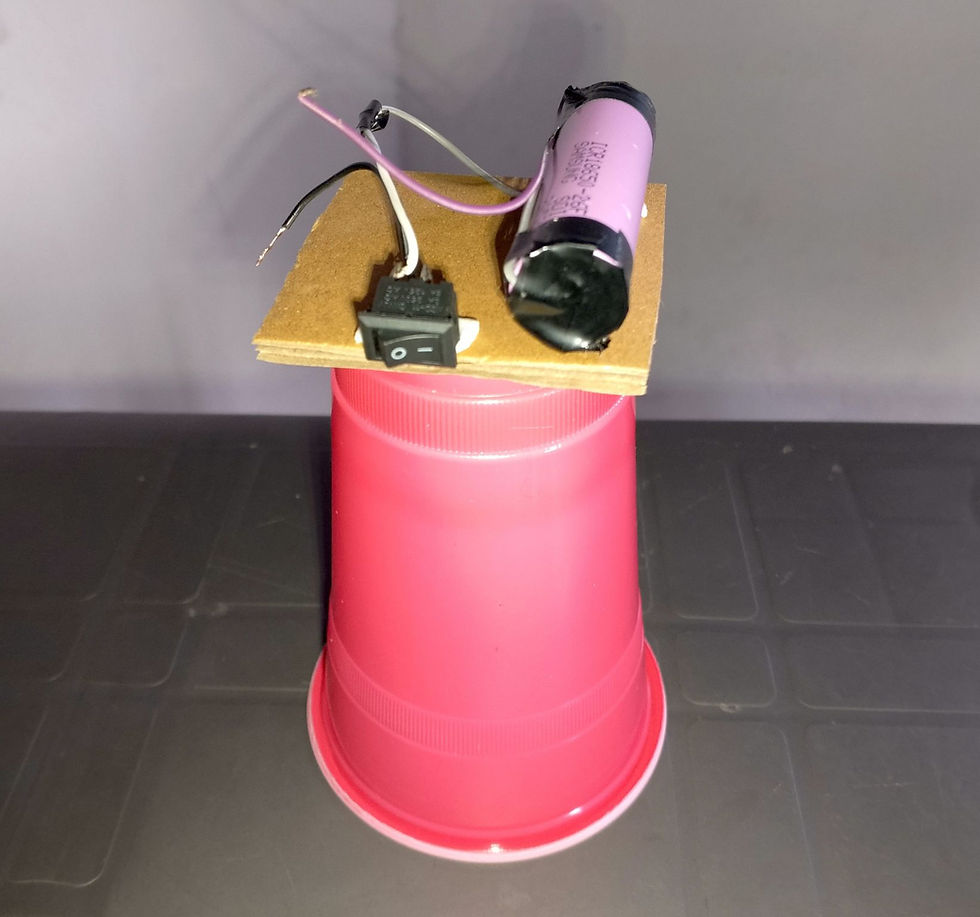 Battery and switch are glued to the cardboard and connected with wires.