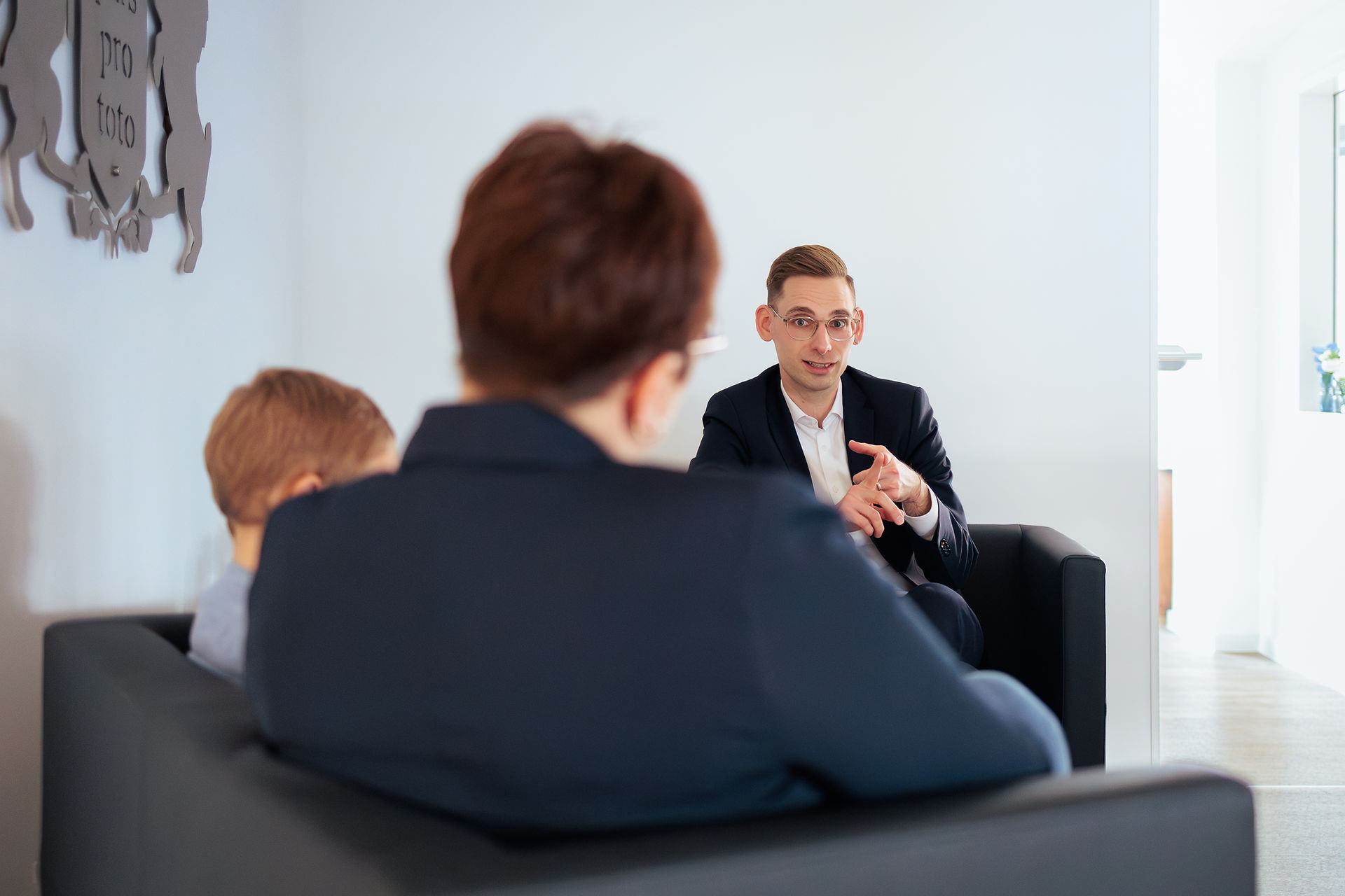 Businessfotografie wo ein Mann einer Mutter mit Kind etwas erklärt