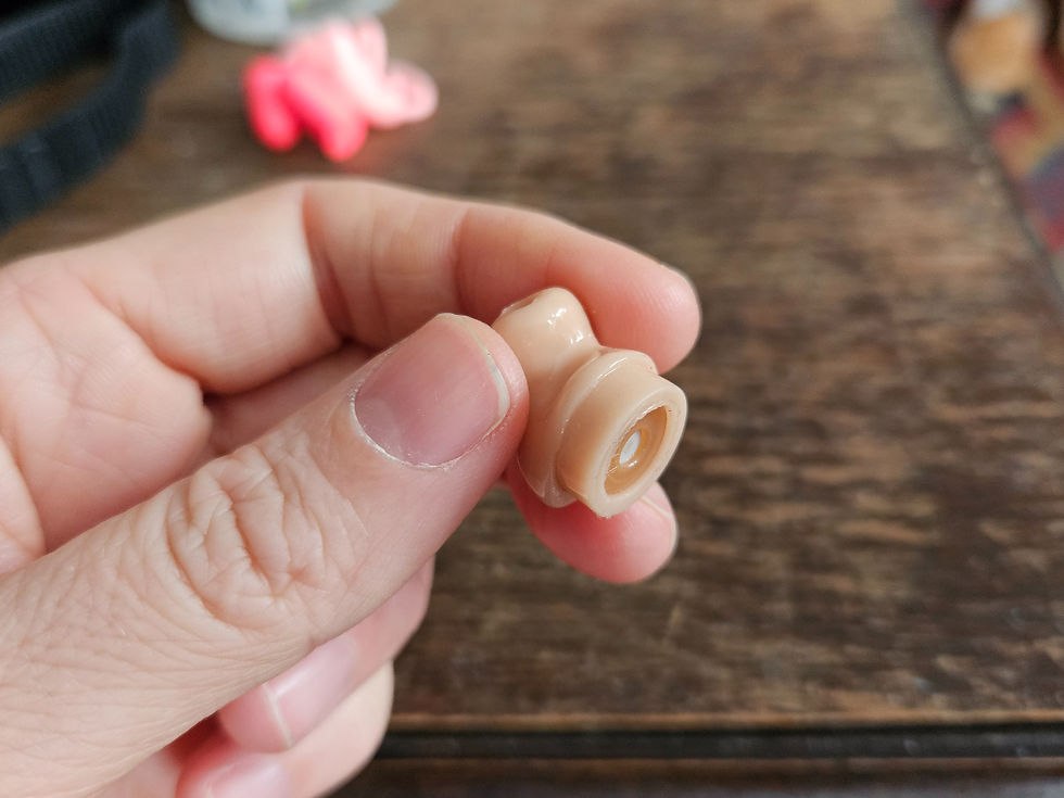 hand holding a custom molded earplug