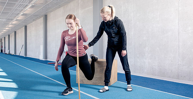 Fysioterapeutti Anu Karp avustaa asiakasta askelkyykyssä Ouluhallilla