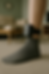 A person wearing an ankle monitor stands on a carpeted floor in a living room, symbolizing house arrest conditions.