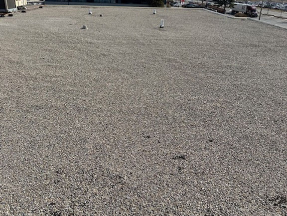 Open gravel-surfaced field of a commercial flat roof beside an office building in Brampton, Ontario, June 2024