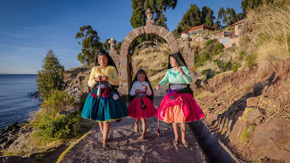 Local Taquile island women in vibrant traditional Andean clothing walking under a stone archway during an exclusive Lake Titicaca private boat tour.