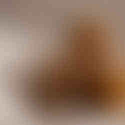 Three warm-toned pillar candles placed on a white tray beside a textured cream blanket, creating a cozy, scent-focused visual for calming interior design. Design A Rose Interiors blog post Which Sense Calms You? How to Design Your Home Around What Soothes You Most.