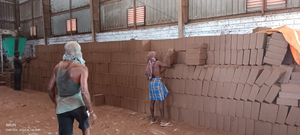 Workers stacking coco peat bricks in a warehouse