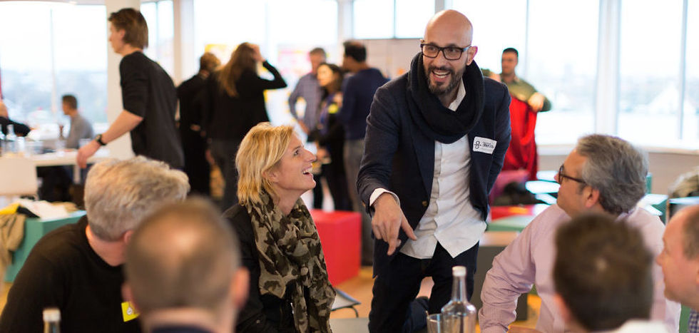 People mingling around a table during a professional networking event.