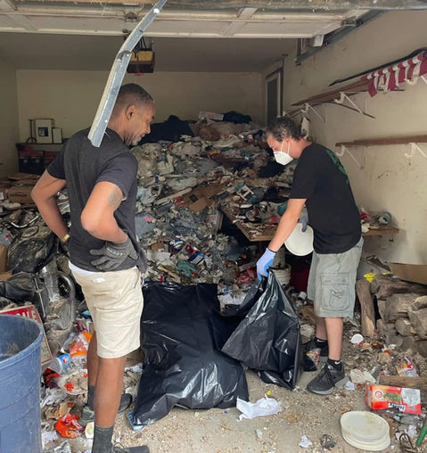 Two crew cleaning out hoarder garbage