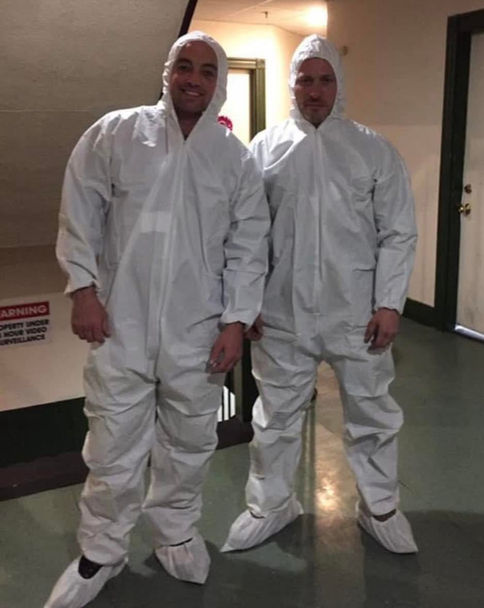 Two crew members posing for a picture in protective suites