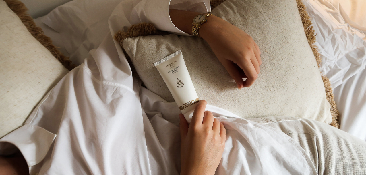 Someone on a bed holding a yesforlov lube tube