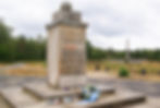 Jewish memorial monument at Bergen-Belsen, bearing Hebrew inscriptions commemorating victims of the camp and invoking remembrance and justice.