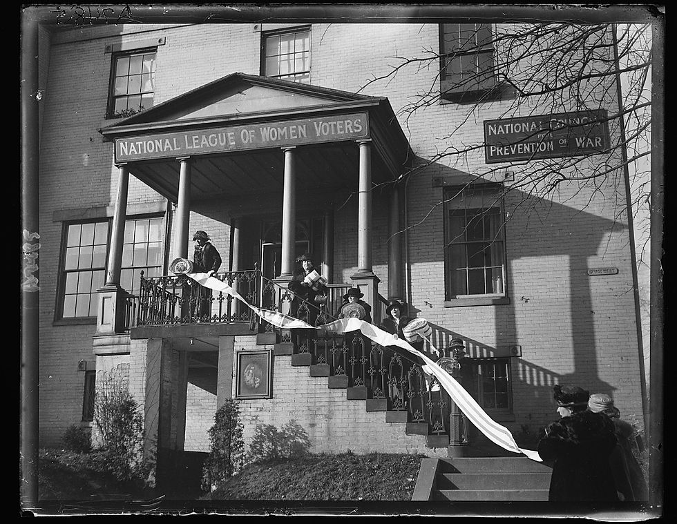 Black and white photo of a group of women holding a document in front of the League headquarters in 1921