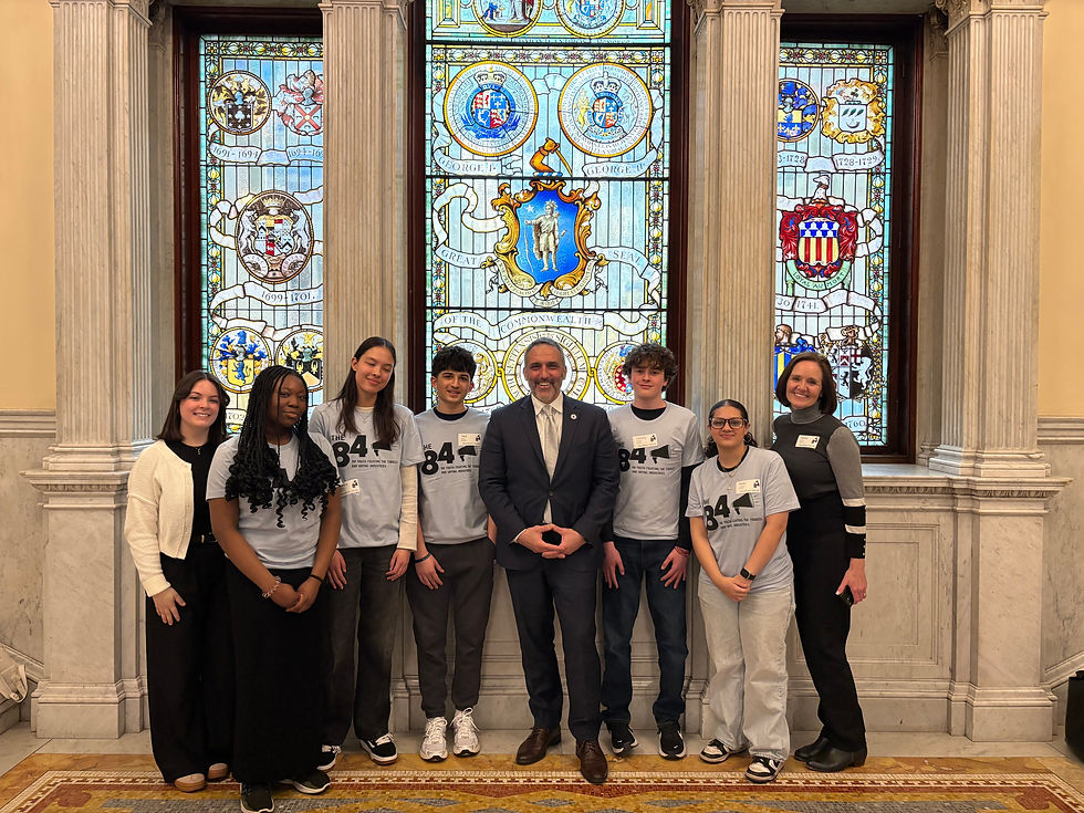 Josh Tarsky is standing with a group of high school students at the State House.