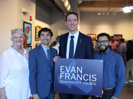 Evan Francis holding a campaign sign with three people smiling