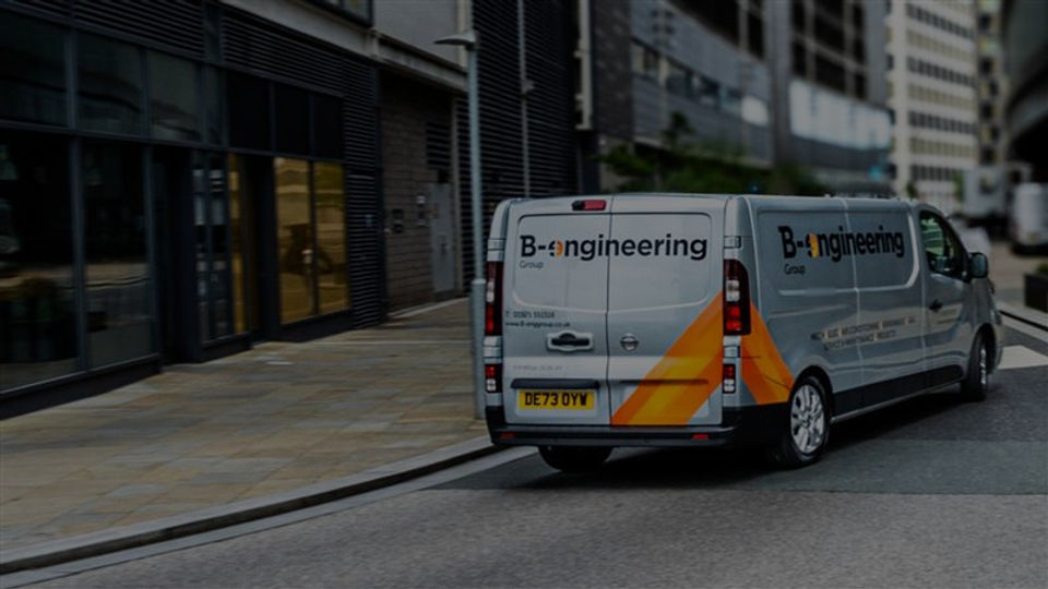 B-engineering van driving through a city street