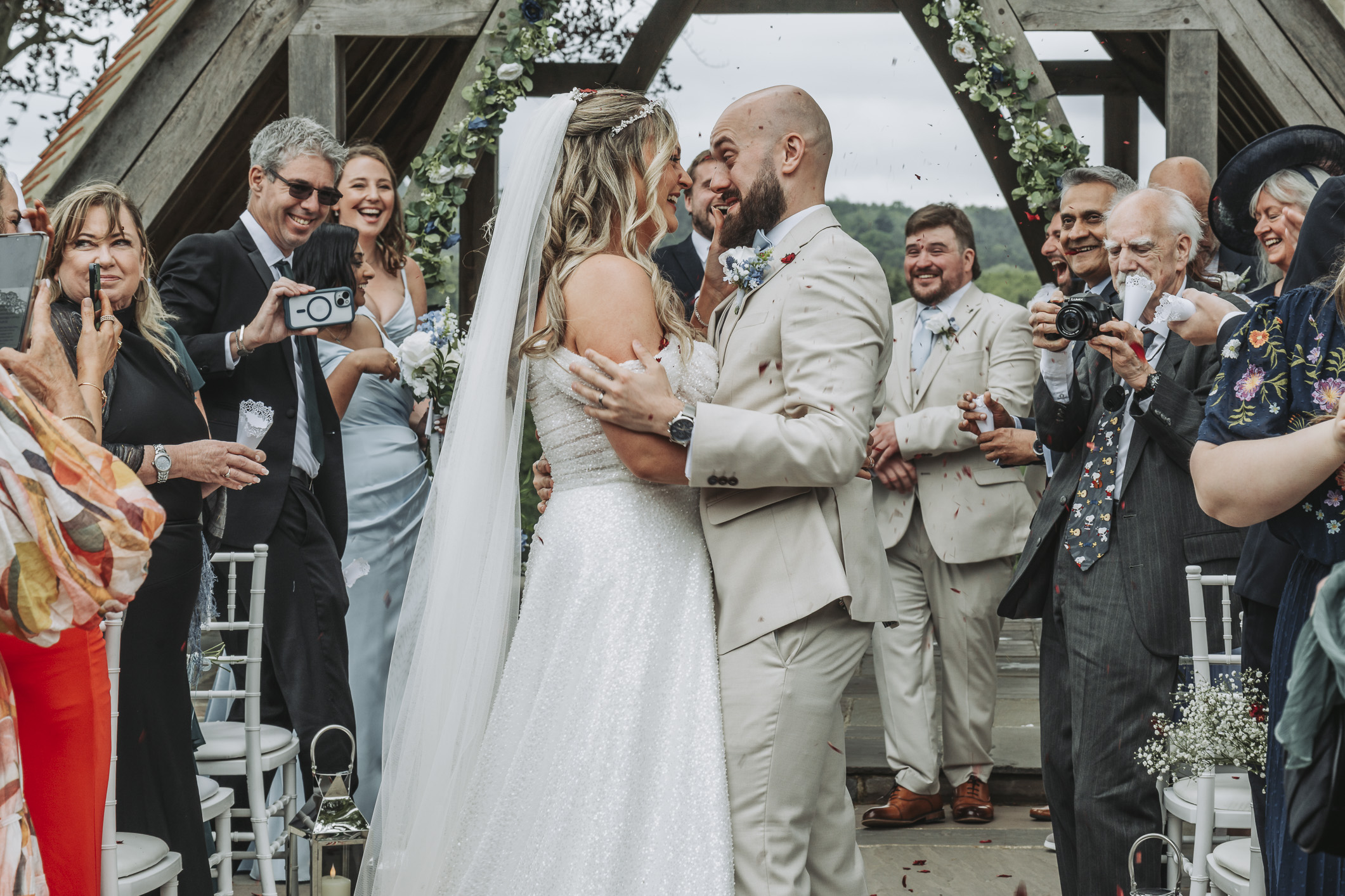 Two professional wedding photographers covering different viewpoints during a wedding ceremony