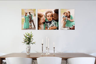 dining room displaying three fine arts wall portraits of a sweet family of three wearing mint green and brown outfits.
