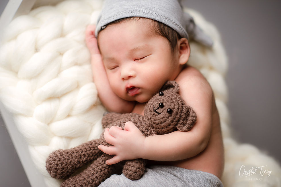 sleeping baby holding brown crochet bear on knitted cream blanket_Ellicott City_Baltimore_Washington DC_Maryland newborn photographer_Crystal Tseng Photography Photo Studio_Baby Photographer_Newborn Photoshoot near me_Portrait Studio_Photo Studio