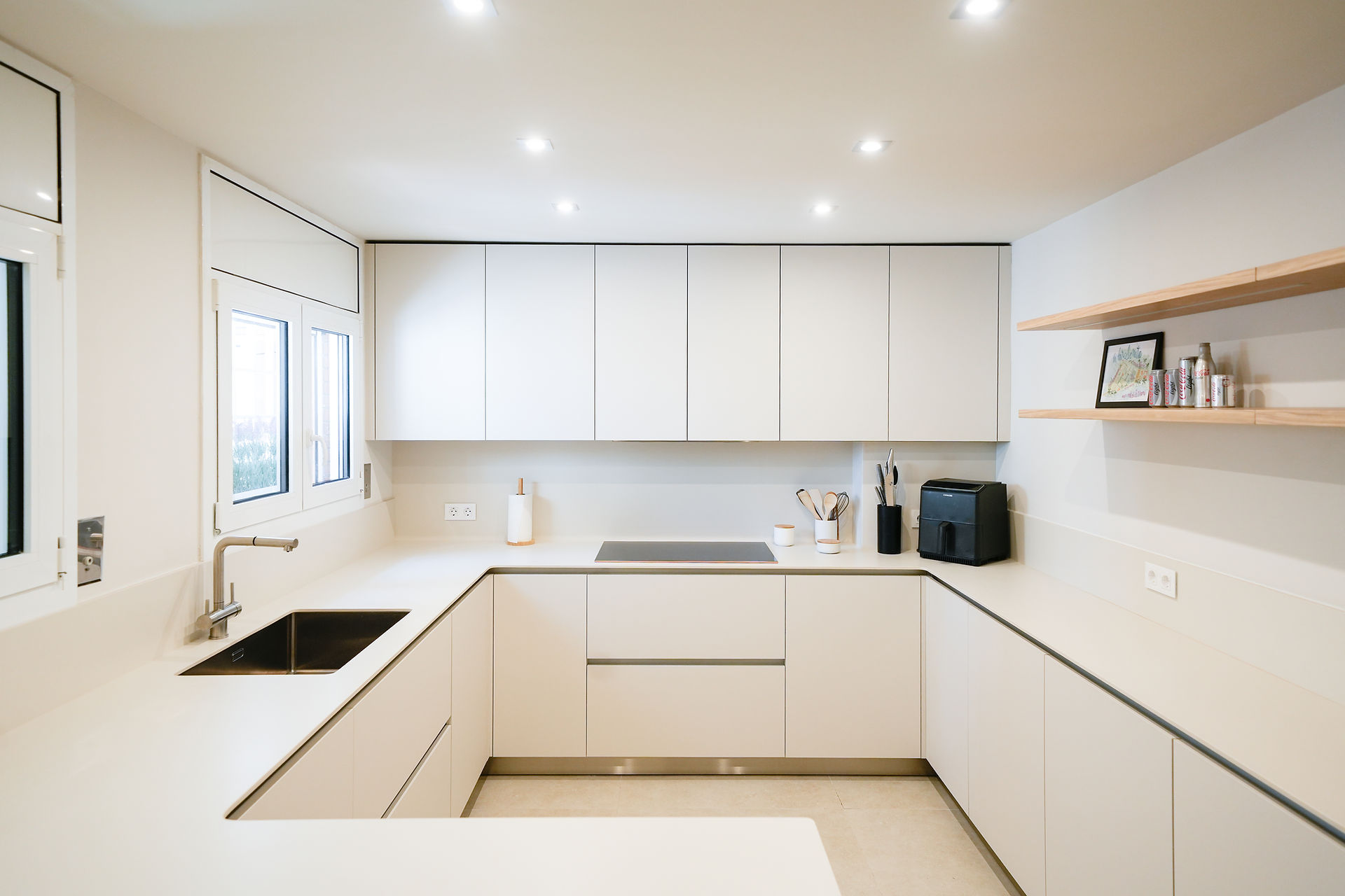Overview of a minimalist kitchen in cream tones with an integrated peninsula 