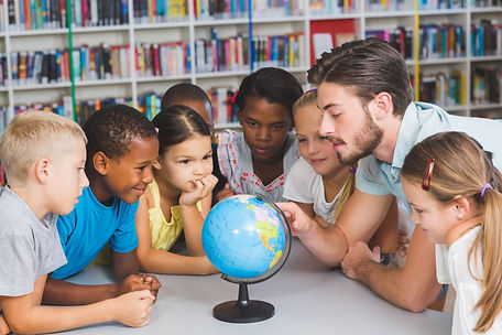 students gathered around a globe