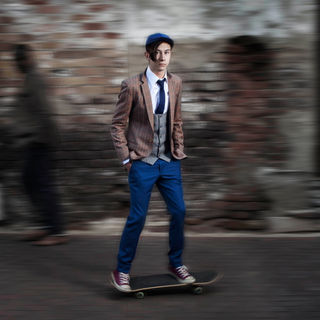 A young man skating in a tailored suit as part of f promotional shoot for a taylor in Joha