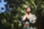 Happy calm young Hispanic woman holding hands in namaste meditating doing yoga breathing e