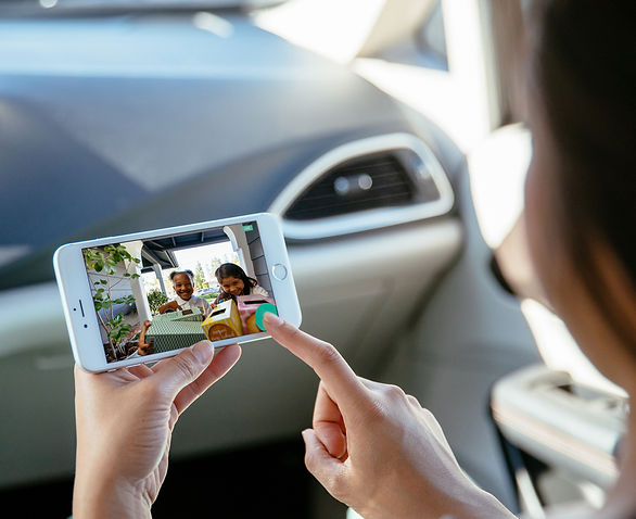 "Young woman reviewing her Vivint doorbell camera on her cell phone"