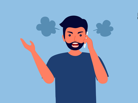 Man in a dark blue shirt talking on a cell phone with a customer service representative.